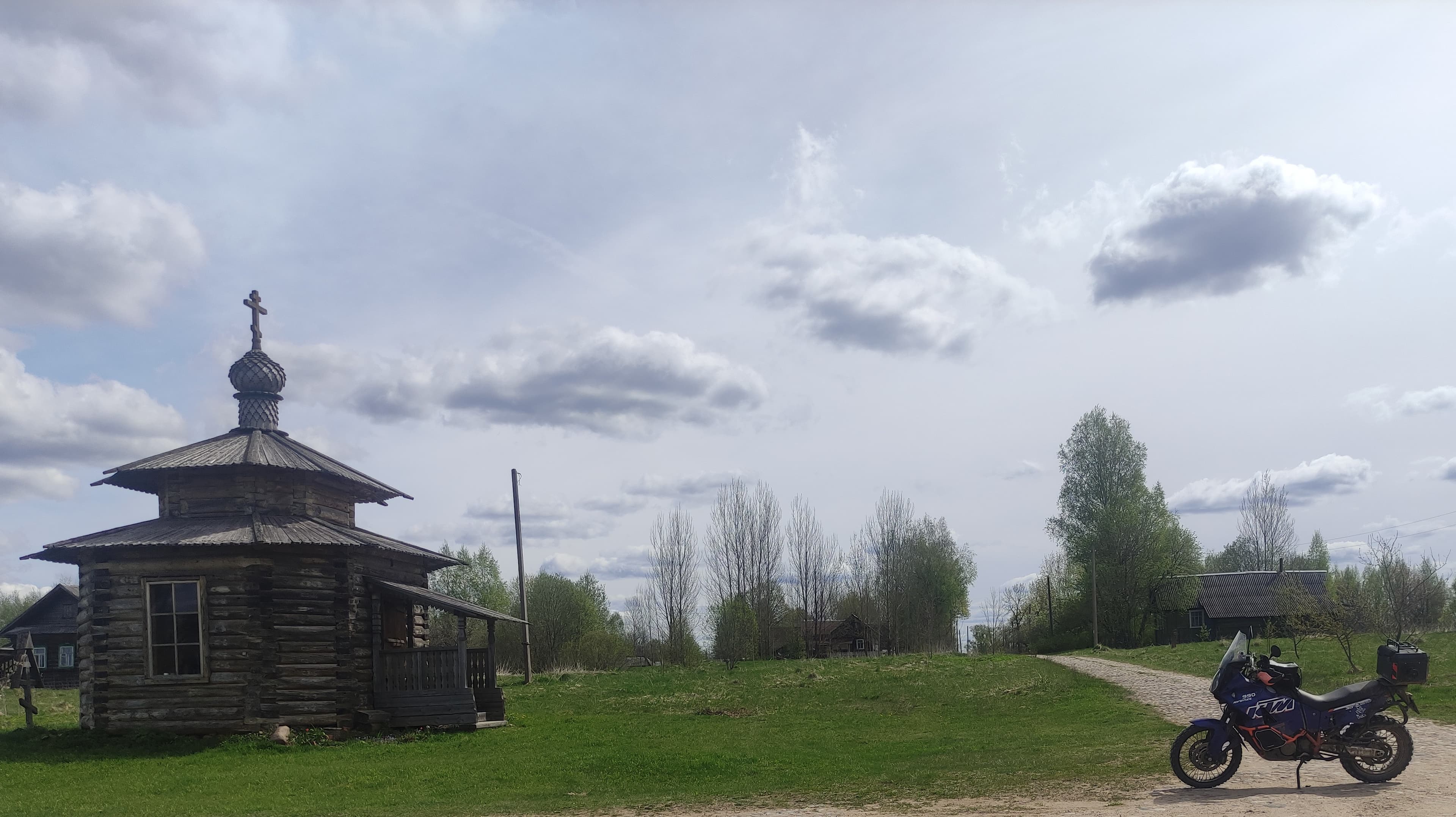 Мотоцикл на брусчатке у деревянной церкви